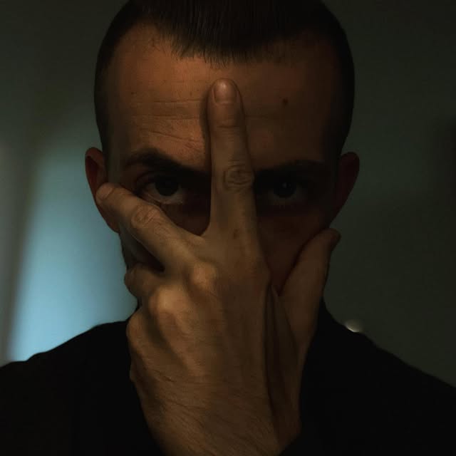 Dunkles Portrait von VEYNE mit einer Hand vor dem Gesicht